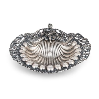 un plat en forme de coquillage argenté, orné de perles sur fond blanc