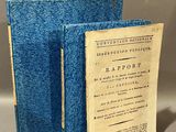 an old book sitting on top of a table next to a blue book