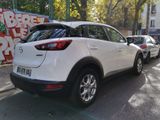 the back of a white mazda cx - hr parked on the side of a street
