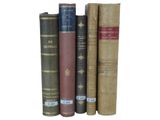 several old books are stacked on top of each other on a white surface