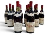 six bouteilles de vin sont alignées sur une surface blanche
