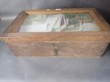 a wooden box with a glass top filled with old photos