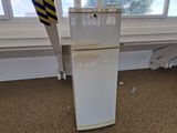 a white refrigerator sitting in a room next to a window