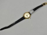 a close up of a watch on a white surface with a black strap