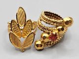 a close up of a pair of gold rings with red stones