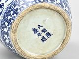 a blue and white vase with chinese writing on it