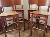 trois tabourets de bar en bois dans une pièce au sol carrelé