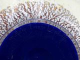 a close up of a blue glass bowl on a table