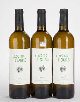 trois bouteilles de vin posées les unes à côté des autres sur une surface blanche