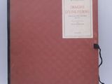 an old book with a red cover sitting on a white surface