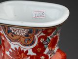 a vase that has a red and white design on it