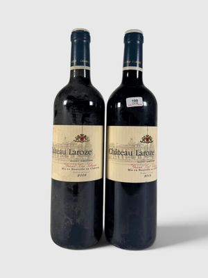 deux bouteilles de vin rouge posées l'une à côté de l'autre sur une surface blanche