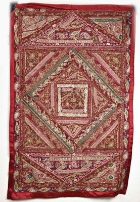 a red and gold tapestry hanging on a white wall