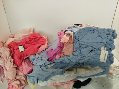 a pile of clothes sitting on a shelf in a room