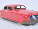 a red toy car that is sitting on a white surface