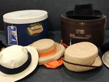 Plusieurs chapeaux sont alignés sur une table à côté d'un seau