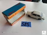 une petite voiture miniature posée sur une table à côté d'une boîte