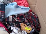 a cardboard box full of clothes and a pair of shoes