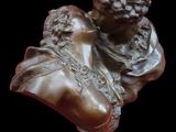 buste en bronze représentant une femme tenant un oiseau, posé sur un socle en bois