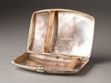 a small silver box with a handle on a table