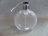 a clear glass bottle with a metal pump on a table