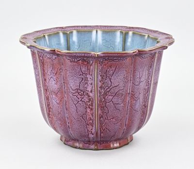 un vase violet posé sur une surface blanche