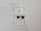 gros plan d'une paire de boucles d'oreilles sur une surface blanche