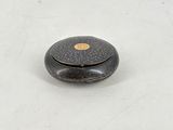 an antique black and gold box sitting on top of a white surface