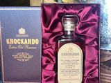 a bottle of liquor sitting in a box on a table