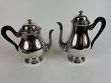 pair of silver plated teapots with black handles