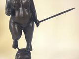 statue of a boy with a sword and a cat on a stand
