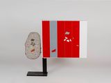 a red and white cabinet with a rock on it