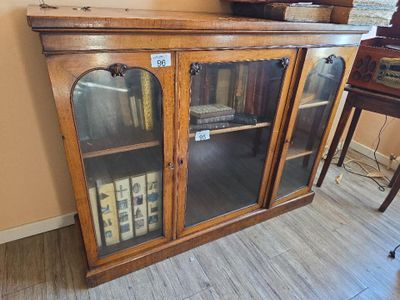 a wooden cabinet with glass doors and a clock on top of it