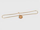 a gold necklace with an owl charm on a chain