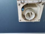a dirty white toilet in a bathroom with a blue wall