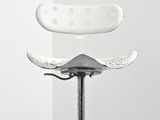a white chair that is sitting on top of a metal stand