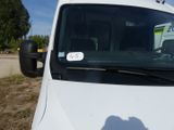 une camionnette blanche garée sur un parking, avec un autocollant sur le pare-brise