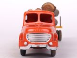 a red toy truck with logs on the back of it
