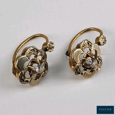 deux paires de boucles d'oreilles posées sur une surface blanche