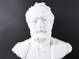a close up of a bust of a man with a beard on a black background