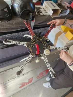 a man sitting on a couch holding a remote control helicopter