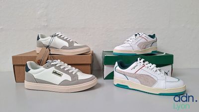 trois paires de baskets blanches et grises posées sur des cartons