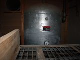 a metal tank with a clock on it in a room