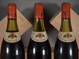 three bottles of wine sitting on a wooden crate