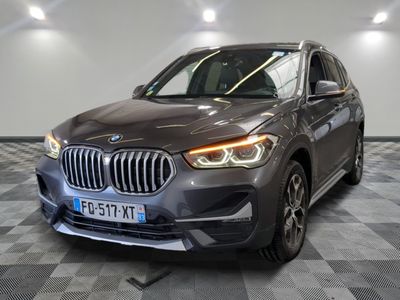 La BMW X1 est garée dans un showroom dont le sol est en damier.