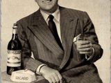 un homme en costume-cravate tenant une bouteille de vin