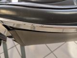 a close up of a black leather chair on a tiled floor
