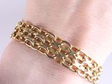 gold plated bracelet with a chain link on a woman ' s wrist