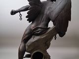 a statue of an angel sitting on top of a bell