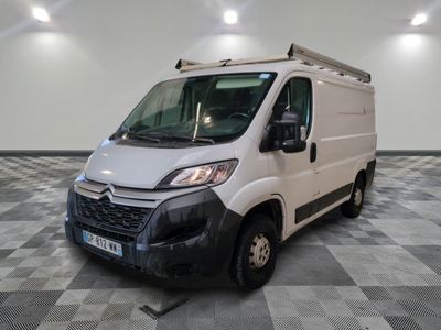 une camionnette blanche garée sur un sol en damier